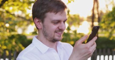 Akıllı Telefon kullanan genç bir kadın, şehirde cep telefonu olan çekici bir kadın. Mercek Fişeği.