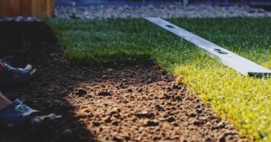 Çimenlik Yuvarlayan Adam. Çim yapıyorum. Yavaş bir hareket yap. Tanımlanamayan bahçıvan elleri yeşil çimlerden mükemmel bir çim oluşturuyor. Peyzaj tasarımı üzerinde çalışan kişi.