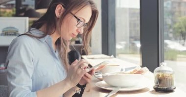 Kadın Elleri Kafede Akıllı Telefon Kullanıyor. Yavaş hareket, dengeleyici. İş kadını bir kafede sosyal medyada mesajlaşıyor, iletişim kuruyor, internette çalışıyor, interneti arıyor, öğreniyor.