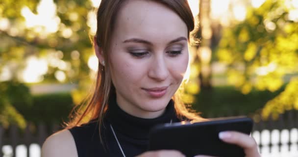 スマートフォンを使用して若い女性 市内の携帯電話で魅力的な女性 レンズフレア — ストック動画