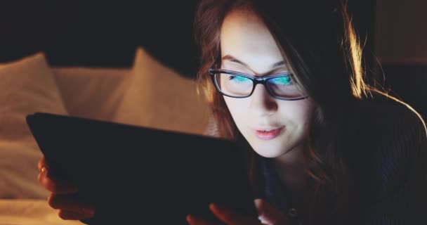 Frau Die Nachts Tablet Computer Benutzt Und Eine Brille Trägt — Stockvideo