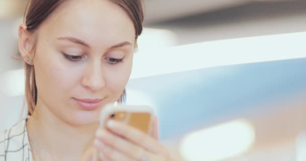 Portrait de femme d'affaires utilisant le téléphone intelligent à l'espace de co-travail, Gros plan. 4K LENT MOTION, DCi. Jeune femme attrayante, en utilisant un téléphone portable dans le bâtiment en verre moderne. Communication et technologie — Video