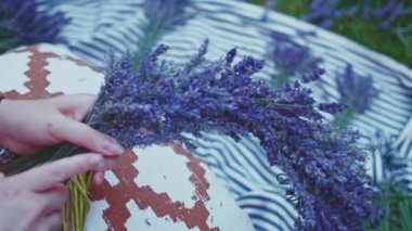 Lavanta Çelengi Yapan Kadın. Yavaş bir hareket yap. Tanınmayan kadın çiçekçi elleri saf lavanta çiçekleriyle süsleme yapıyor. Provence Fransız bahçesinde huzurlu bir gecenin tadını çıkaran bir kız..