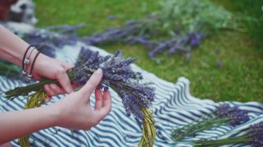 Lavanta Çelengi Yapan Kadın. Yavaş bir hareket yap. Tanınmayan kadın çiçekçi elleri saf lavanta çiçekleriyle süsleme yapıyor. Provence Fransız bahçesinde huzurlu bir gecenin tadını çıkaran bir kız..