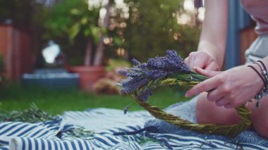 Lavanta Çelengi Yapan Kadın. Yavaş bir hareket yap. Tanınmayan kadın çiçekçi elleri saf lavanta çiçekleriyle süsleme yapıyor. Provence Fransız bahçesinde huzurlu bir gecenin tadını çıkaran bir kız..