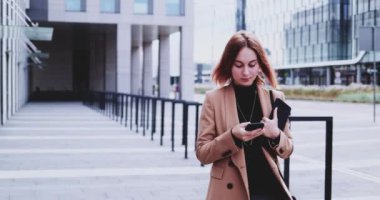 Şehirde Dolaşan Akıllı Telefon Kullanan İş Kadını. Yavaş hareket Gimbal dengelendi. İnternette kadın girişimci ağı, daktilo, mesaj, öğrenme, sabah ofise koşuşturma.