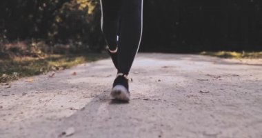 Tanımlanamayan Koşucu Kadın Ayakları parkta koşuyor, dışarıda egzersiz yapıyor. Gimbal Stabilize atış 4K. Yavaş bir hareket yap. Sporcu kadın koşu yaparken yalın ayak spor ayakkabısı giyer. Lens fişeği. Sağlıklı Yaşam Tarzı.