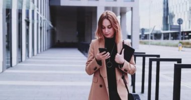 Şehirde Dolaşan Akıllı Telefon Kullanan İş Kadını. Yavaş hareket Gimbal dengelendi. İnternette kadın girişimci ağı, daktilo, mesaj, öğrenme, sabah ofise koşuşturma.