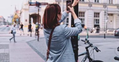 Şehirde akıllı telefon kullanan, video çeken genç bir kadın. Yavaş hareket, Gimbal Dengeleyici. Kadın Blogcu Sosyal Medya için İçerik Oluşturuyor. Yayın hizmetleri, ağ kurma takıntısı. Avrupa seyahati.