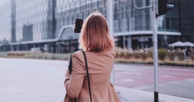 Şehirde Dolaşan Akıllı Telefon Kullanan İş Kadını. Yavaş hareket Gimbal dengelendi. Kadın girişimci, selfie videosu çekiyor. Kişisel markalaşma üzerine çalışıyor, internetten iletişim kuruyor. Sosyal medyaya bağımlılık