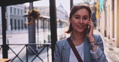 Genç İşkadını Akıllı Telefon Kullanıyor, Güneşli Sabah Şehrinde İşe Gidiyor. Yavaş hareket, Gimbal Dengeleyici. Şehirde cep telefonu olan çekici, profesyonel bir iş kadını. Mercek Fişeği.
