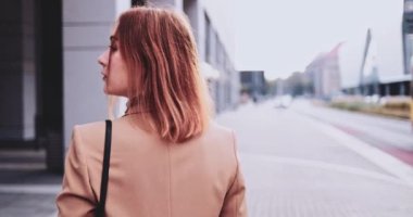 Tabletli ve akıllı telefonlu iş kadını şehirde yürüyor. Yavaş hareket Gimbal dengelendi. Genç Profesyonel Kadın sabah aceleyle ofise geliyor. Finans Bölgesi.