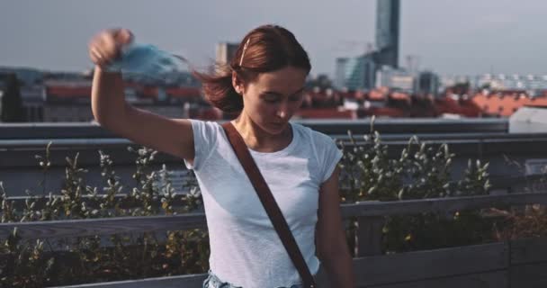 Junge Frau zieht die medizinische Maske ab, um zu atmen. SLOW MOTION, Gimbal Stabilisator. Frauen entfernen Gesichtsmaske gegen Luftverschmutzung und Coronavirus. Ende der Pandemie. Freiheit, frische Luft. — Stockvideo