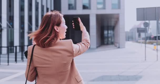 Mujer de negocios usando Smartphone caminando en la ciudad. Movimiento lento Gimbal estabilizado. Empresaria femenina haciendo selfie video trabajando en el branding personal, comunicándose en línea. Adicción a las redes sociales — Vídeos de Stock
