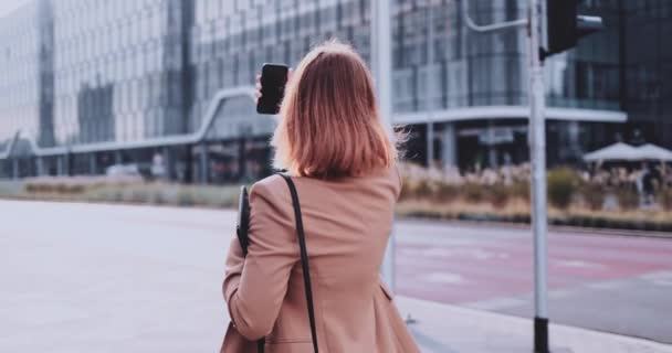 Mujer de negocios usando Smartphone caminando en la ciudad. Movimiento lento Gimbal estabilizado. Empresaria femenina haciendo selfie video trabajando en el branding personal, comunicándose en línea. Adicción a las redes sociales — Vídeo de stock