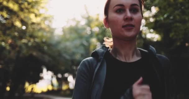 Runner Woman Courir dans le parc Sunny City Exercice en plein air. Gimbal STABILISÉ, MOTION LENT. Entraînement de jogging matinal Sportswoman. Mode de vie sain. Lentille Flare. Mindful Run, Souriant, relaxant. — Video