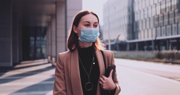 Retrato de uma mulher de negócios usando uma máscara protetora andando na cidade. LOW MOTION Gimbal Estabilizado. Estudante em uma máscara facial médica contra a poluição do ar e coronavírus Covid19 pendulares. — Vídeo de Stock