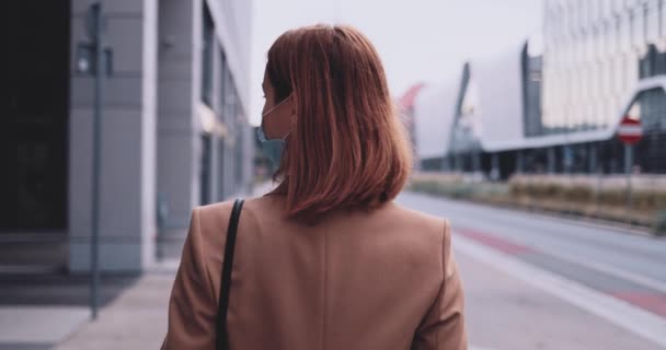 Mujer de negocios con una máscara protectora caminando por la ciudad. Movimiento lento Gimbal estabilizado. Joven profesional en una mascarilla médica contra la contaminación del aire y el coronavirus Covid19 desplazamientos. — Vídeos de Stock