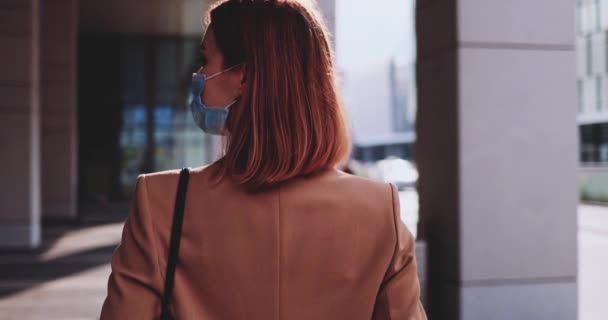 Business Woman bär en skyddande mask promenader i staden. SLOW MOTION Gimbal stabiliserad. Young Professional i en medicinsk ansiktsmask mot luftföroreningar och coronavirus Covid19 pendling. — Stockvideo