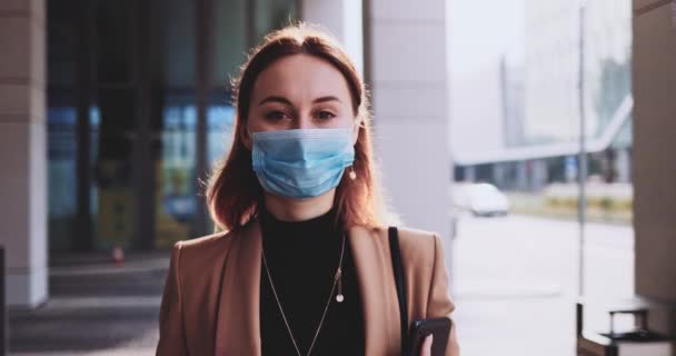 Portrait Of A Business Woman Wearing A Protective Mask Walking In The City. SLOW MOTION Gimbal Stabilized. Student in a medical face mask against air pollution and coronavirus Covid19 commuting. — Stock Video