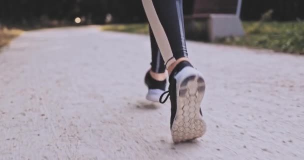 Unrecognizable Runner Donna Piedi Running In The Park Esercizio all'aperto. Colpo stabilizzato Gimbal 4K. SLOW MOTION. La sportiva indossa scarpe sportive a piedi nudi mentre fa jogging. Lens Flare. Stile di vita sano. — Video Stock