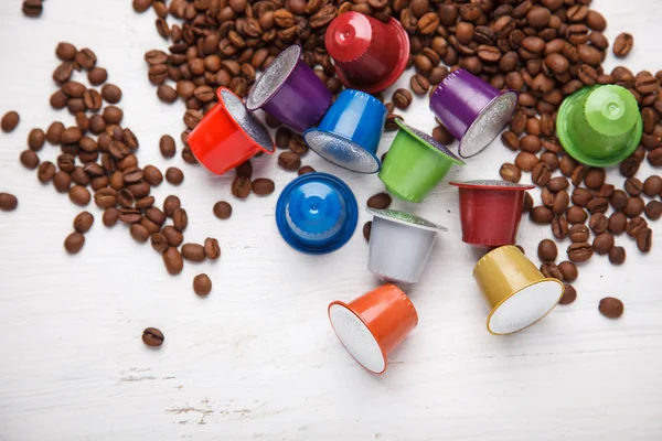 Colorful coffee capsules on coffee beans