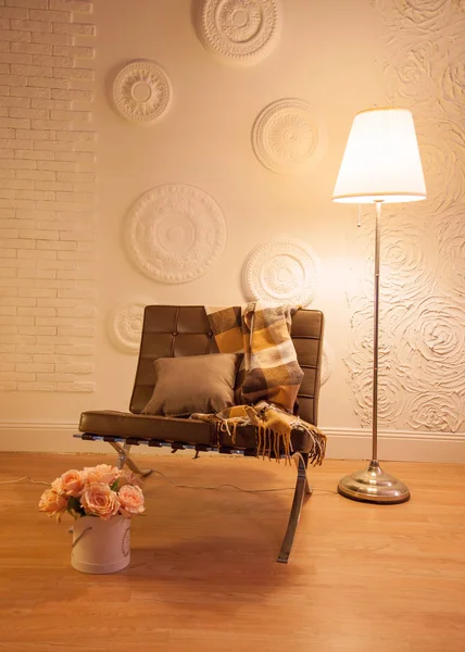 Yüksek tavan, beyaz duvar, ahşap zemin, çelik ve deri mobilya tasarımı ile modern loft oturma odası.