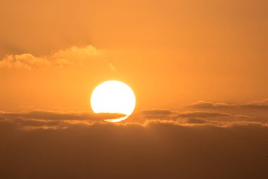 Gün batımında turuncu bir güneşin görüntüsü
