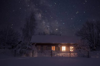 Geceleri yıldızlı gökyüzünün arka planında bir köy evinin fotoğrafı..