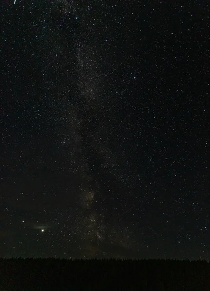 Vía láctea cielo estrellado sobre un bosque en un pueblo ruso — Foto de Stock