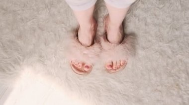 Kabarık pembe terlikler içinde dans eden ayak parmakları olan bir kadın. Rahat ev, evde kal..