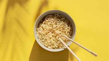 Baharatlı yumurtalı erişte ve sarı arka planda Çin yemek çubukları. En üstteki düz yerde. Geleneksel Asya mutfağı.