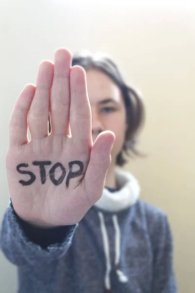 Tiener jongen doen stopbord met palm van een hand — Stockfoto