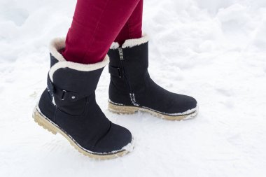 Siyah Çizmeli kış karda yürüyen kadın ayakları