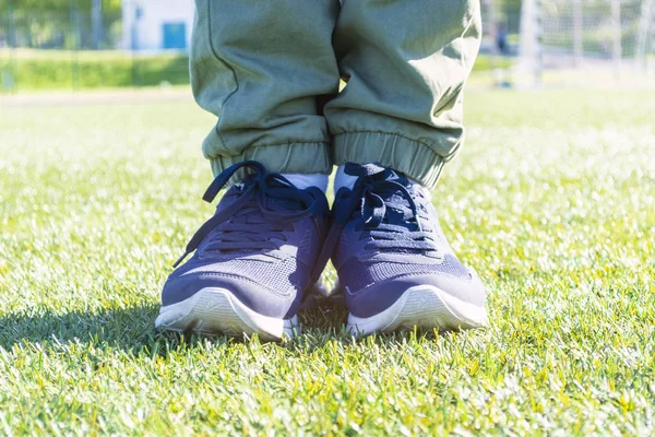 Чоловічі ноги в спортивних кросівках на траві. Вибірковий фокус — стокове фото