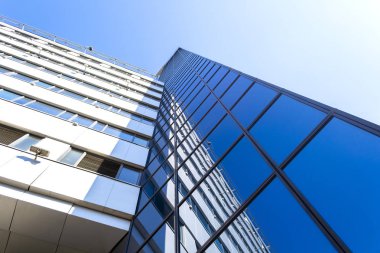 Mavi gökyüzü karşısında cam modern gökdelen bina