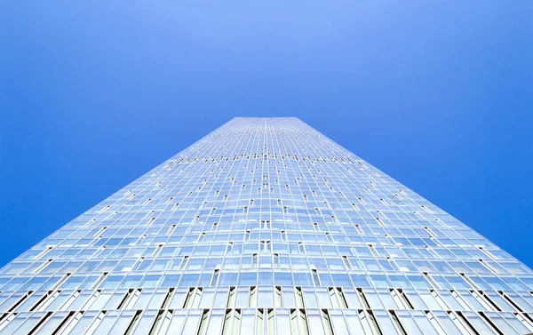 Edifício de arranha-céus moderno de vidro em frente ao céu azul — Fotografia de Stock