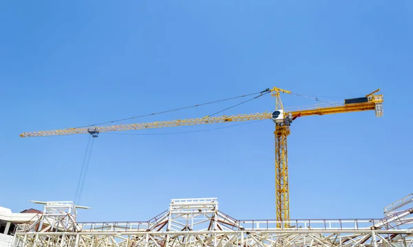 Grúa de construcción sobre el edificio contra el cielo azul — Foto de Stock
