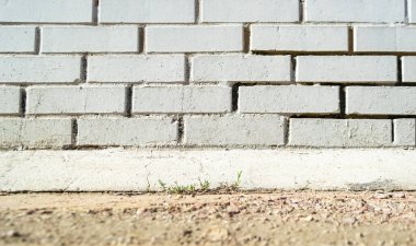 Beyaz tuğla duvar ve çimenli zemin
