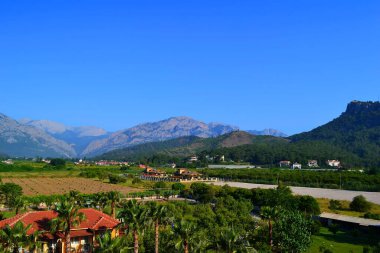 Parlak mavi gökyüzüne karşı dağlar ve yazın güzel bulutlar.