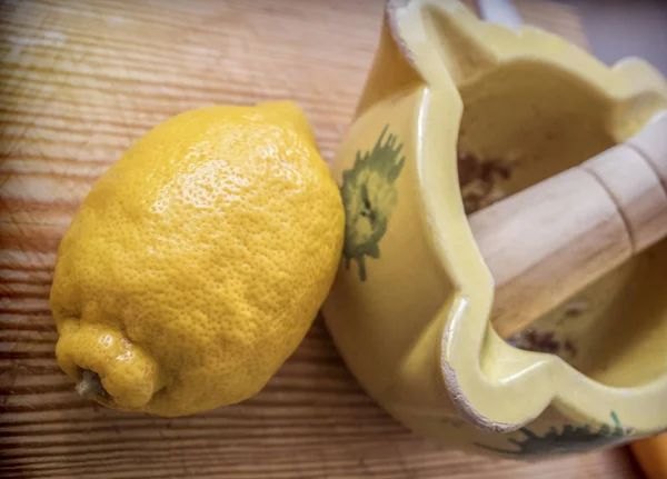 Traditional ceramic mortar next to a lemon in a kitchen, traditional cooking utensils