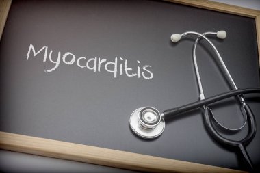 Word Myocarditis written in chalk on a blackboard black next to a stethoscope, conceptual image clipart