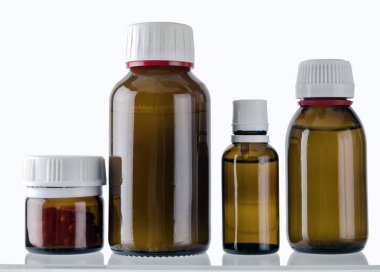 Kozmetik kapları ve beyaz zemin üzerine izole ilaçlar farklı