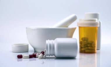 Kapsül kırmızı ve beyaz dışında harç eczacı, kavramsal görüntü yanında bir şişe