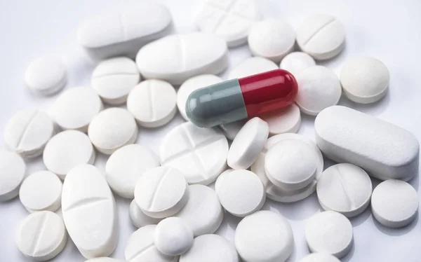 カプセル ピンクといくつかの錠剤にブルー 概念的なイメージ — ストック写真
