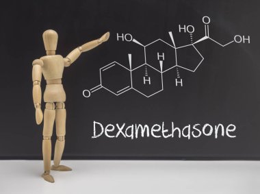 Doll articulated indicating in a whiteboard chemical composition of Dexamethasone, conceptual image clipart