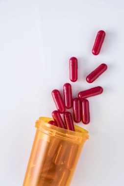 capsules going out of a bottle, conceptual image, vertical composition clipart
