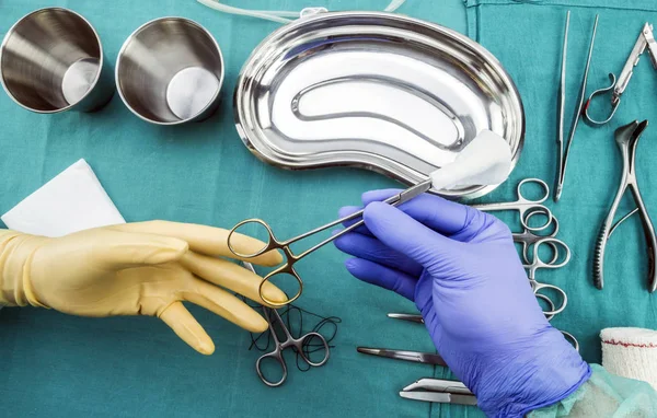 Cirujano trabajando en quirófano, manos con guantes sosteniendo tijeras de sutura y torundas, imagen conceptual, composicon horizontal —  Fotos de Stock