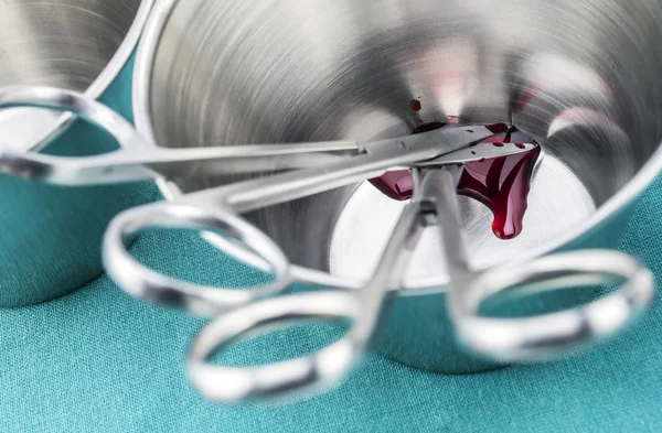 Tijeras quirúrgicas empapadas de sangre en una bandeja metálica en un quirófano, composición horizontal, imagen conceptual — Foto de Stock