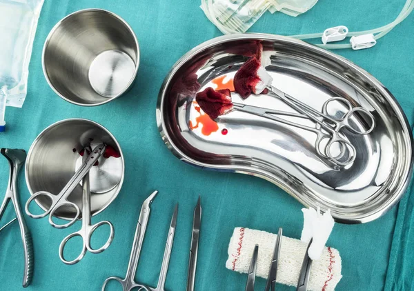 Tijeras quirúrgicas con torundas empapadas de sangre en una bandeja metálica en un quirófano, composición horizontal, imagen conceptual — Foto de Stock